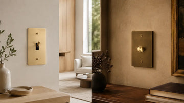 Satin brass toggle hardware in a bright contemporary interior contrasted with an antique brass dimmer in a warmer traditional setting.