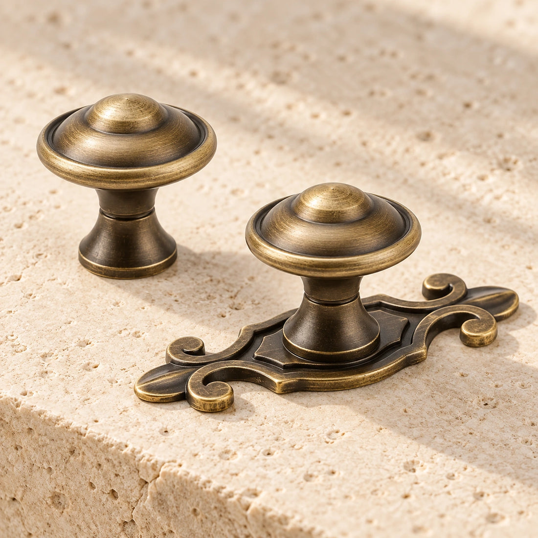 Antique brass domed cabinet knobs with and without ornate backplate on limestone