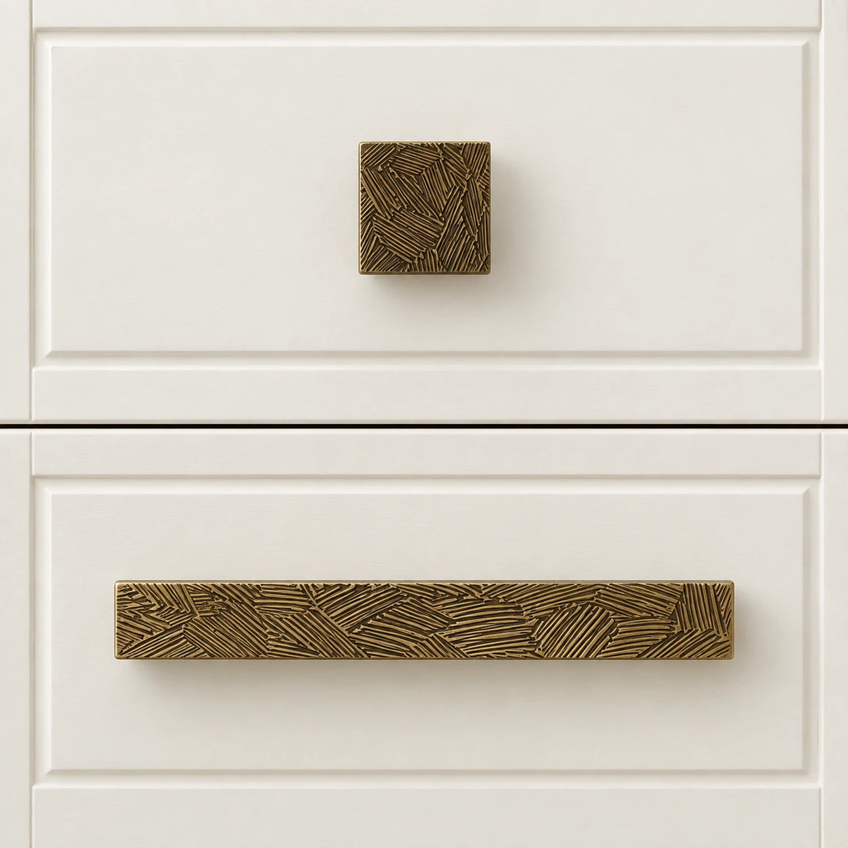 Textured antique brass square knob and bar pull installed on ivory drawers
