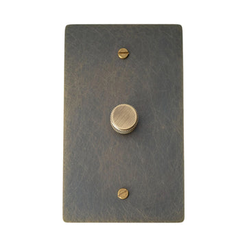 Bronze brass dimmer switch plate with antique knob on a white background