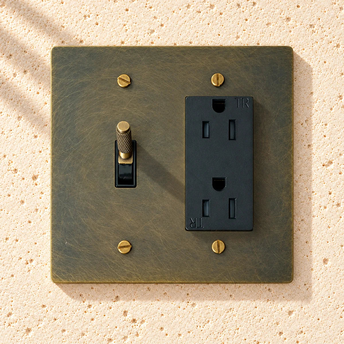 Antique bronze wall plate with toggle switch and outlet on a white background