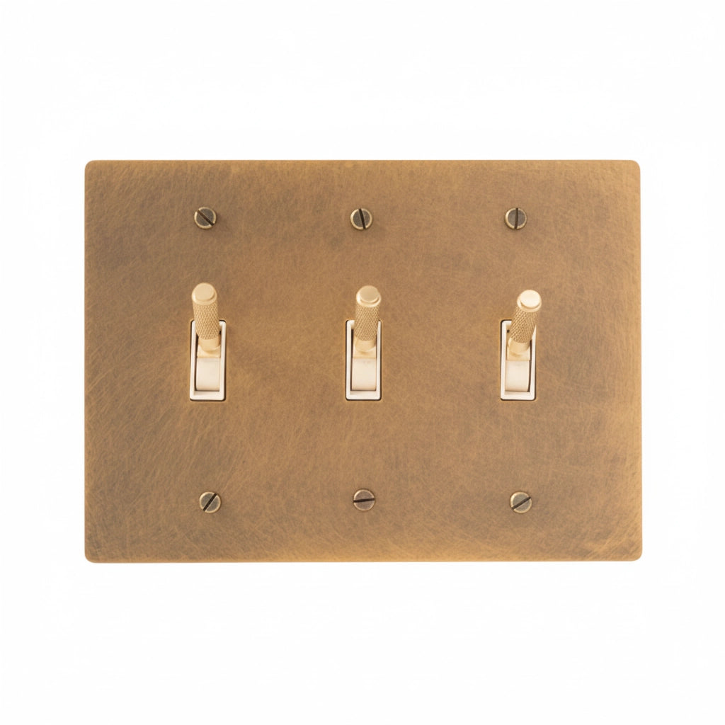 Close-up of knurled toggle detail on antique brass 3-gang switch plate