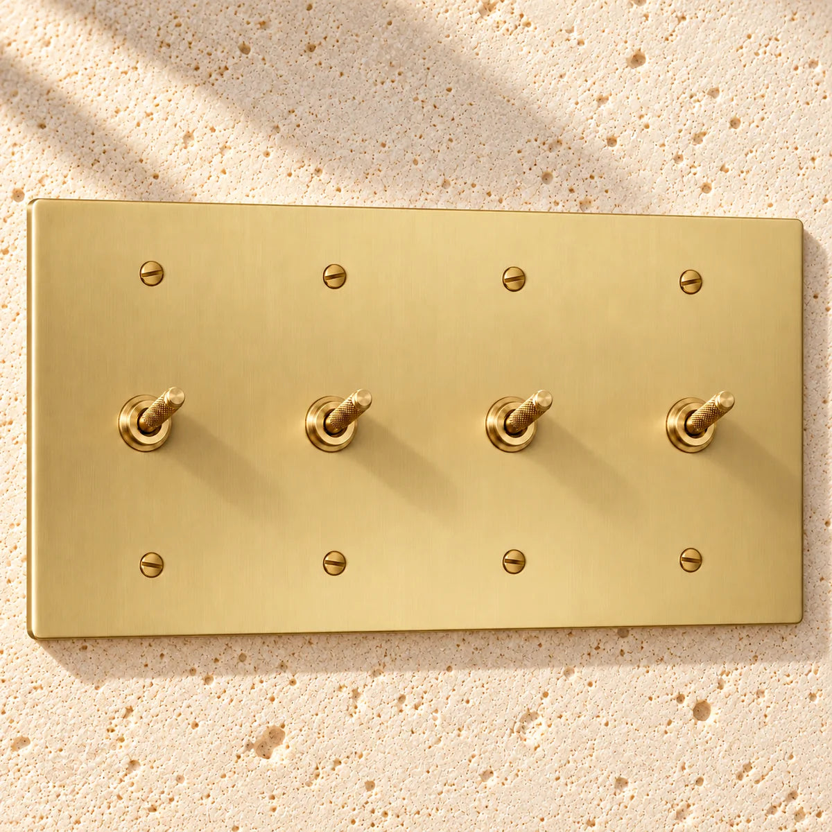 4-Gang Solid Brass Knurled Toggle Light Switches in Satin Brass; 4 toggles on a white background