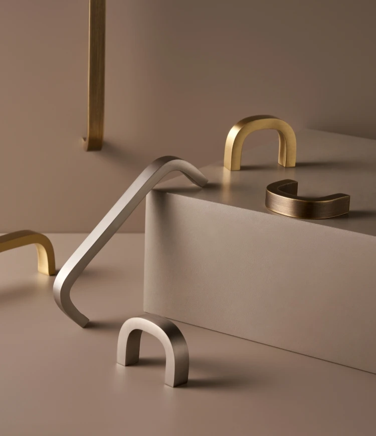 Set of gold and silver cabinet handles on a neutral background
