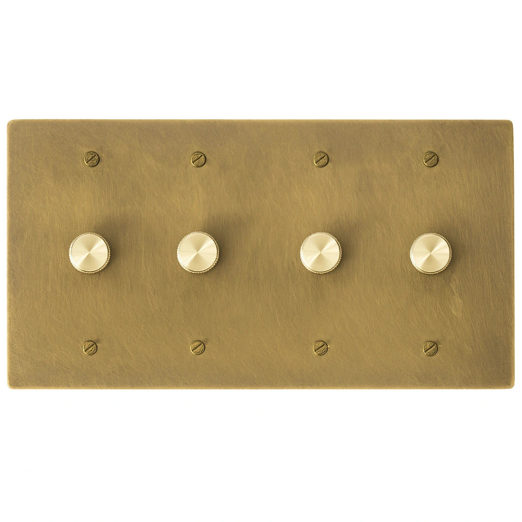 Four gang antique brushed brass dimmer switch panel with smooth rotary knobs and matching brass screws.