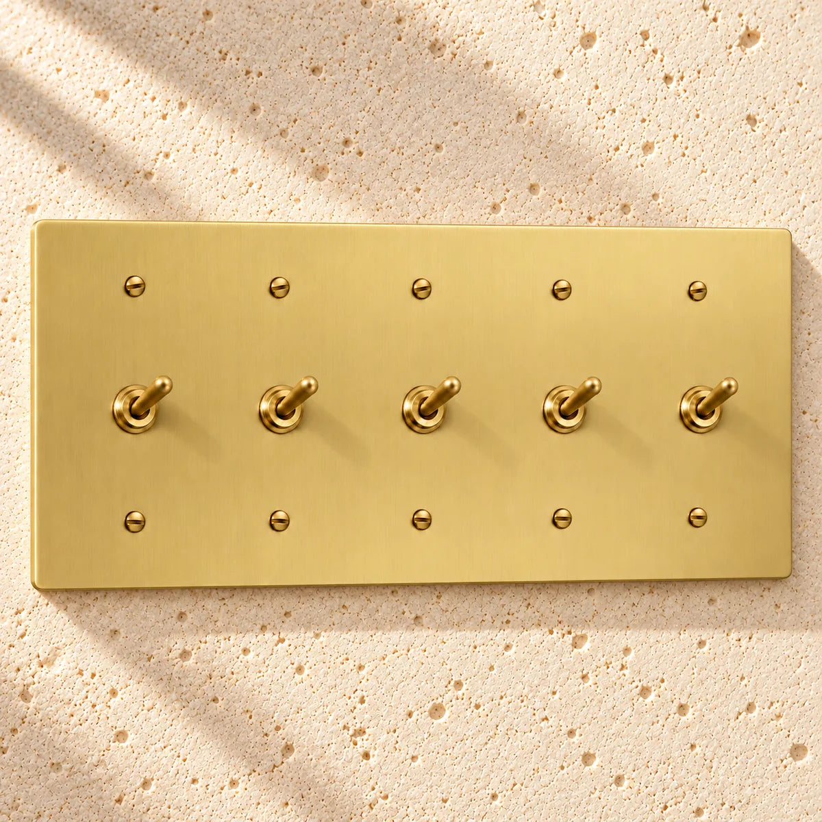5-Gang Solid Brass Toggle Light Switches in Satin Brass; 5 toggles on a white background