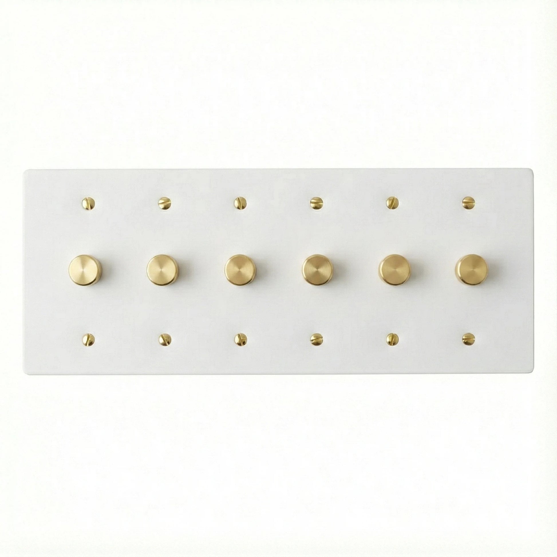 White 6 gang brass dimmer wall plate with gold screws on a white background
