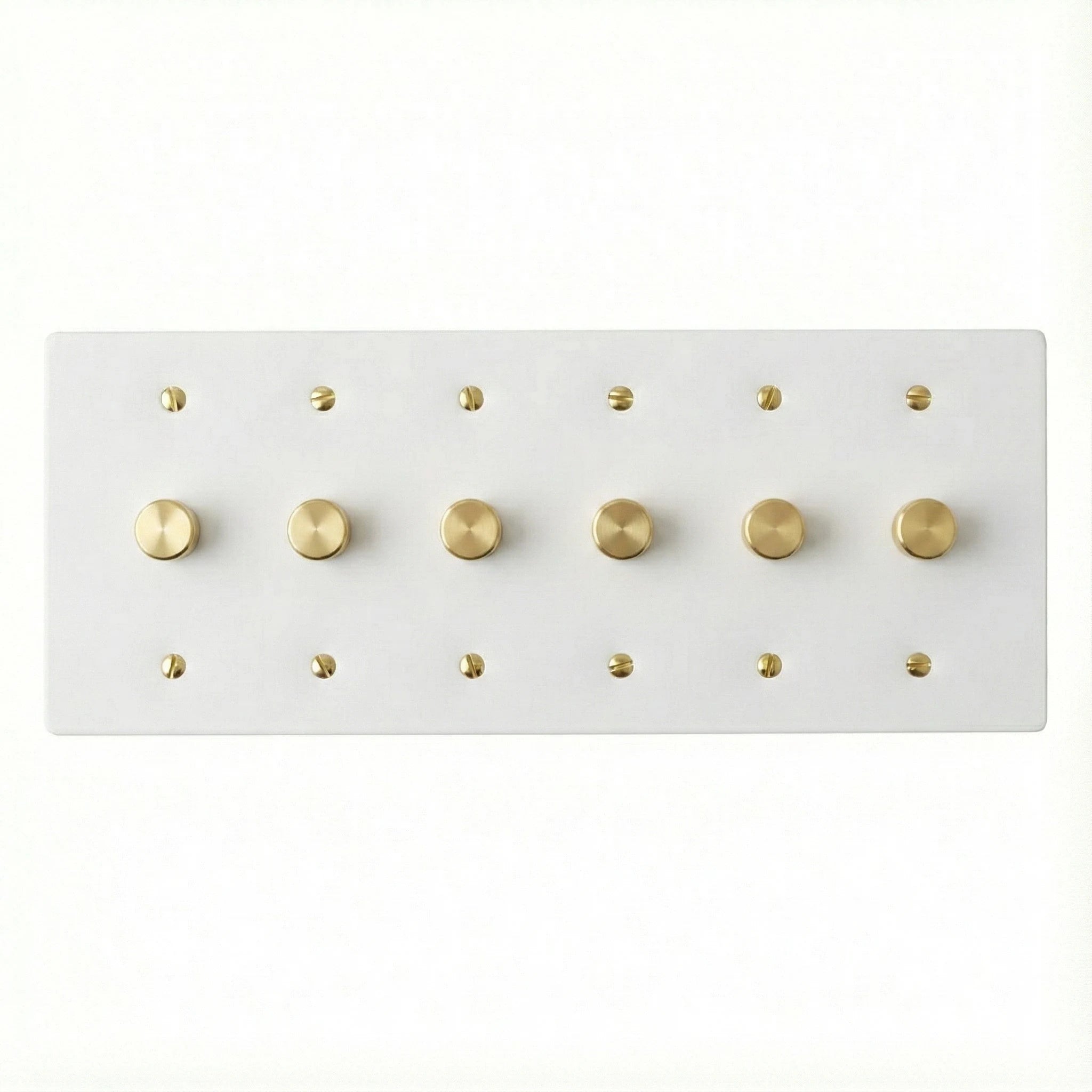White 6 gang brass dimmer wall plate with gold screws on a white background
