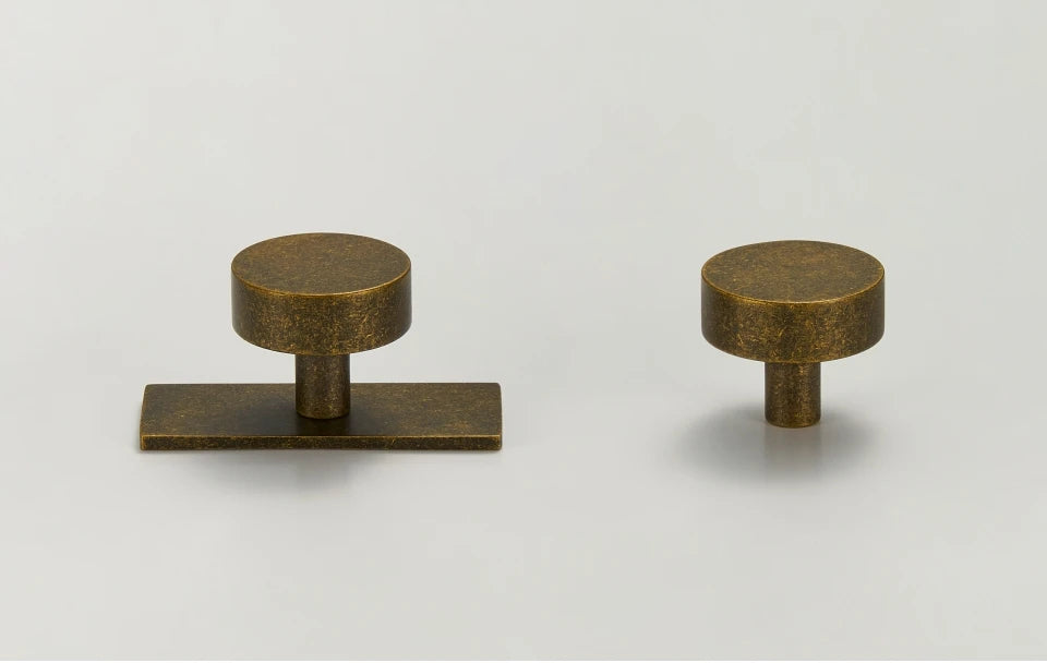 Two antique brass ice flower vintage door knobs on a white background.