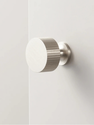 Art deco vertical line door knob on a white door.