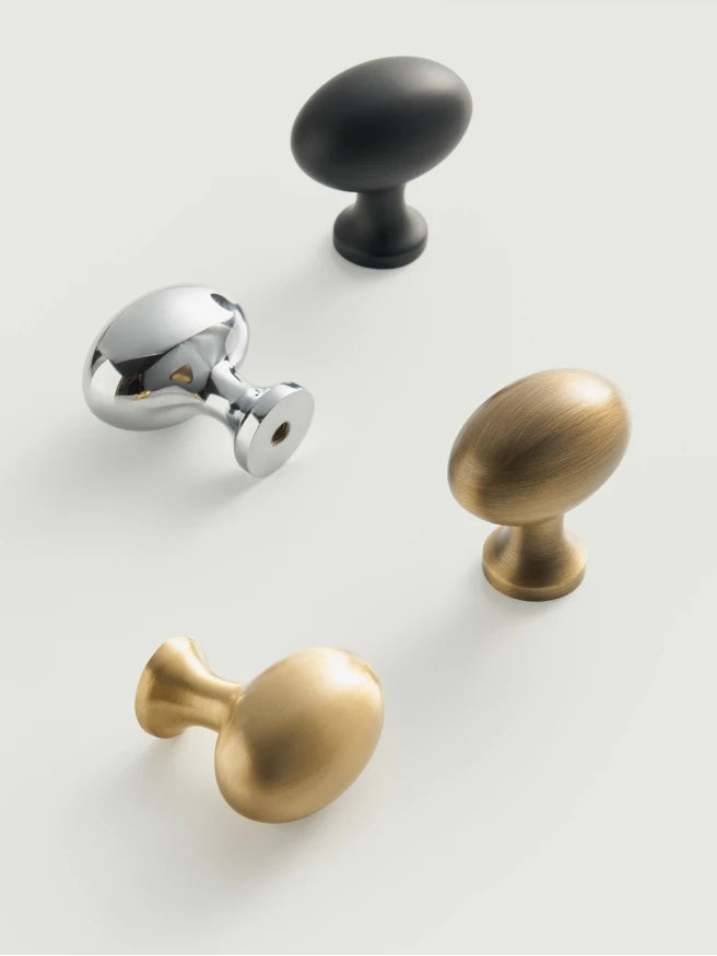 Set of cabinet knobs in black, silver, and gold on a white background. 