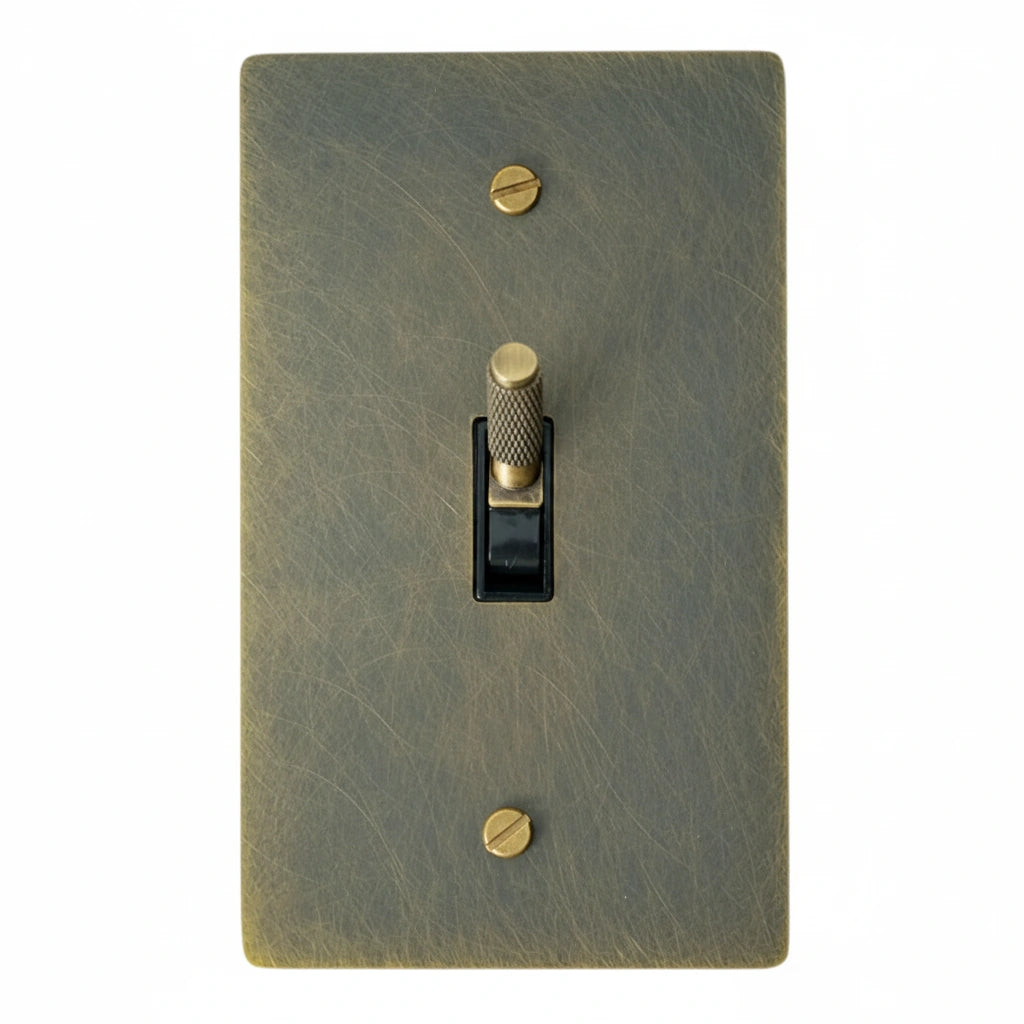 Bronze-colored light switch cover with a toggle switch on a white background