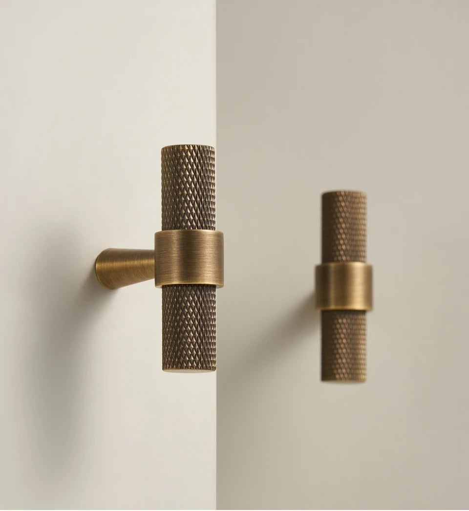 Pair of bronze textured brass t-bars on a neutral background.