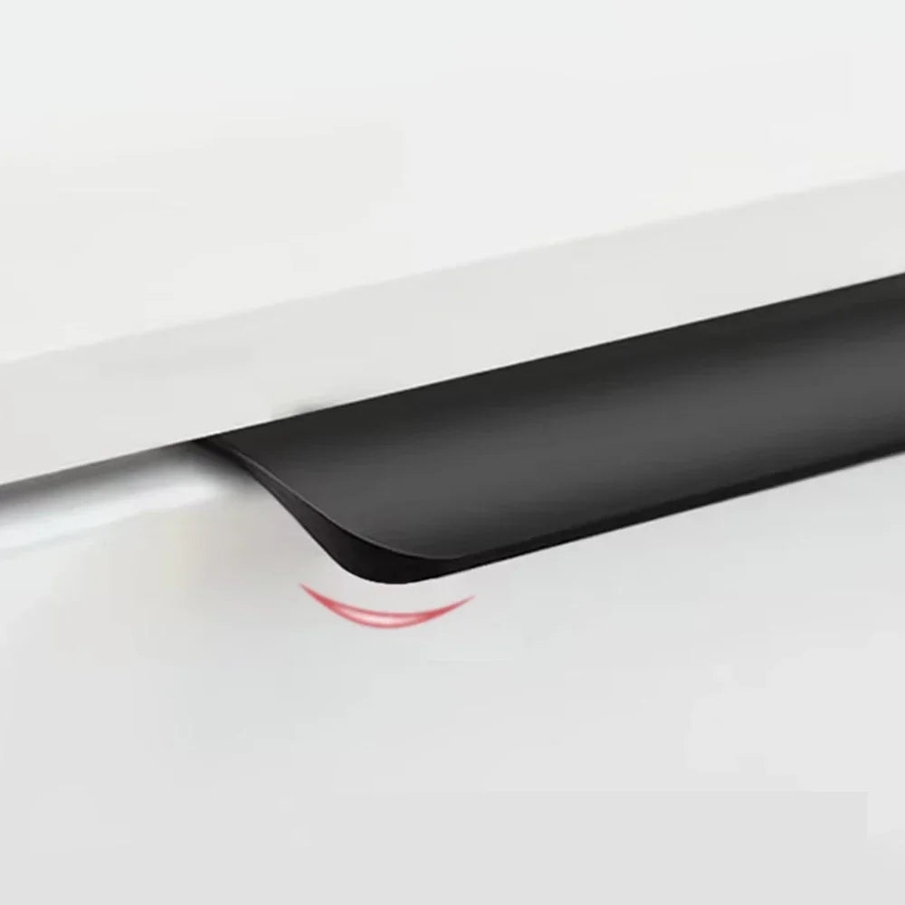 Close-up of a black edge pull showing rounded corner on a white cupboard drawer.