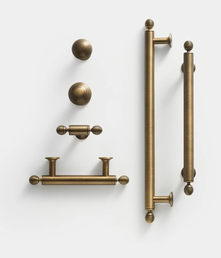 Collection of vintage-style solid brass antique ball cabinet knobs, t-bars and handles hardware on a white background.