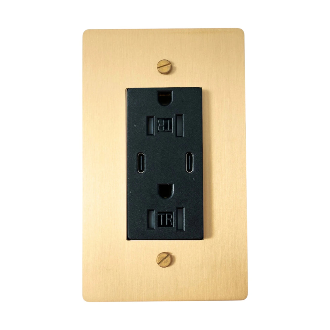 Black electrical outlet on a gold wall plate with screws