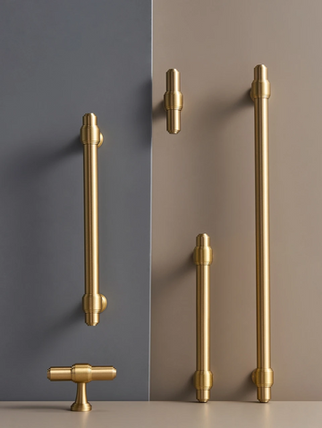 Set of solid brass European luxury design gold handles and knobs on a grey and beige background.