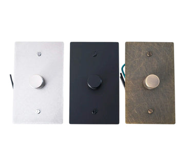 Three wall light switches in white, black, and wood finish on a white background