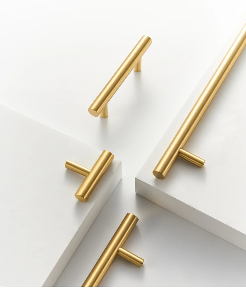 Four gold brass round rod pulls and knob on a white background.