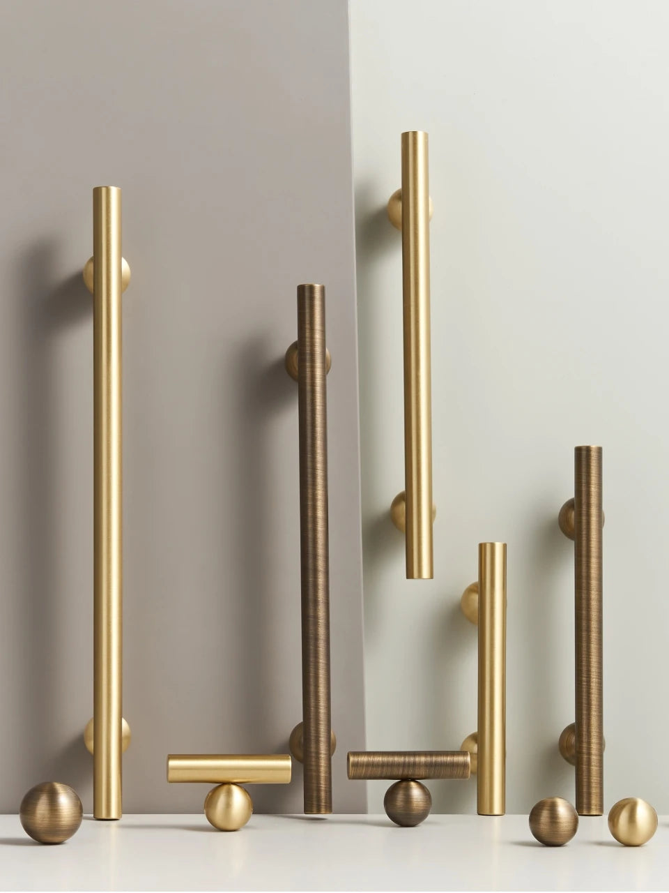 Set of gold and antique brass round ball handles, t-bars and knobs on a neutral background.