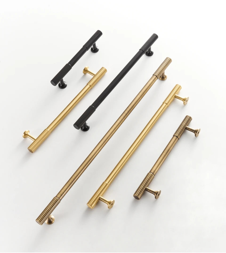 Set of gold, antique and black brass Art Deco pulls on a white background.