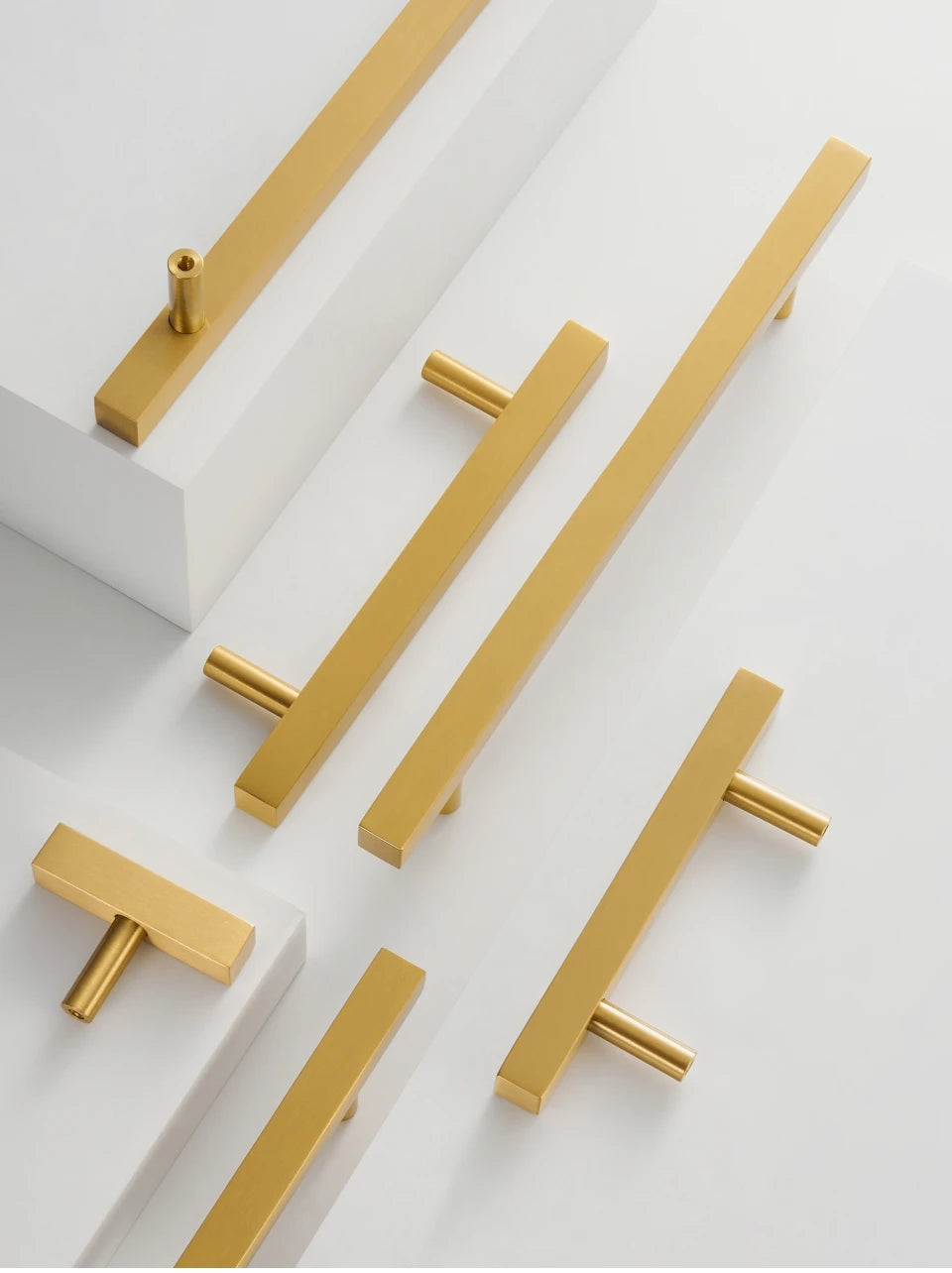 Gold brass square cabinet handles and t-bar on a white background