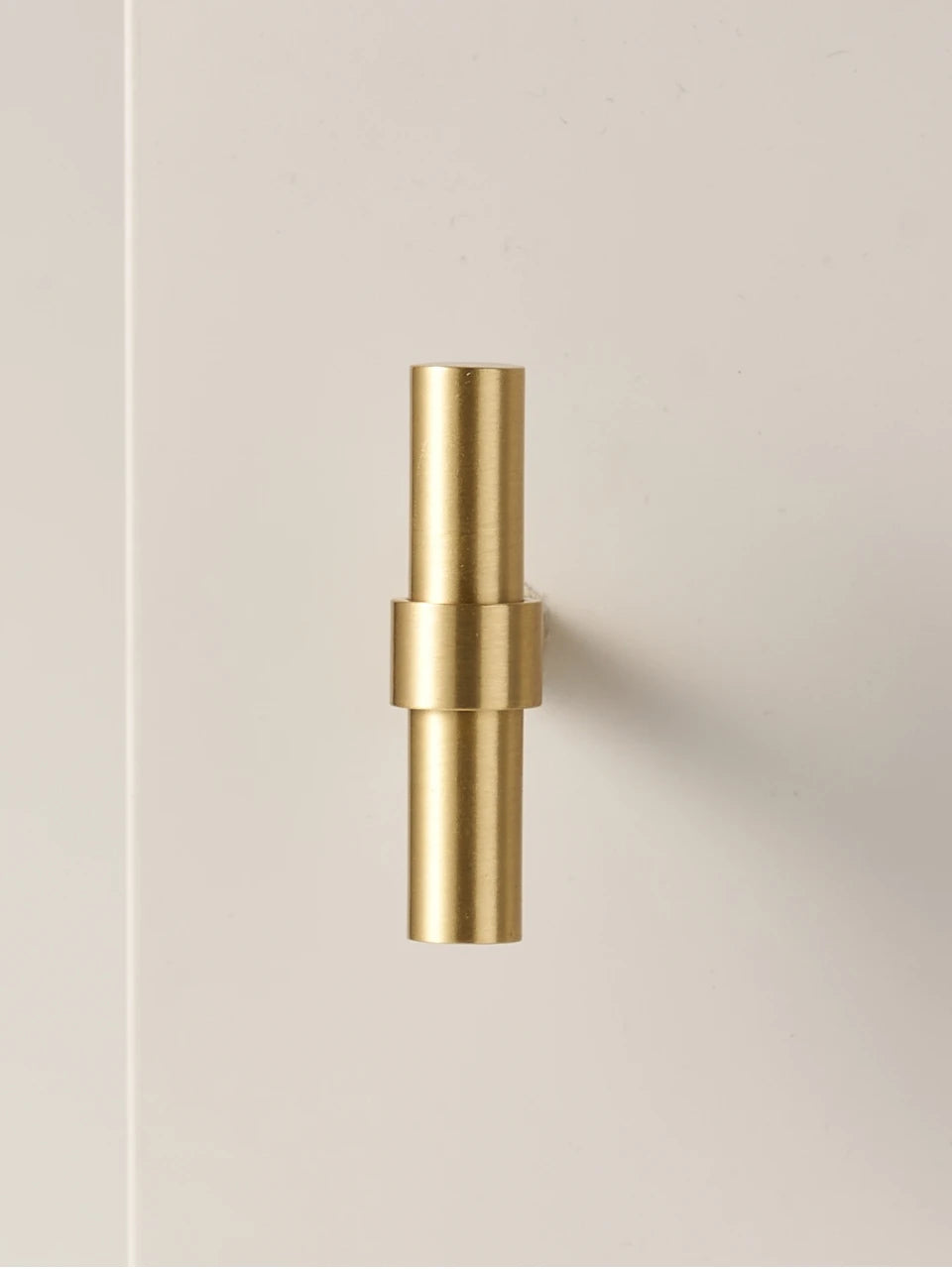 Set of gold and antique brass stepped ring door handles and t-bars on a beige background.