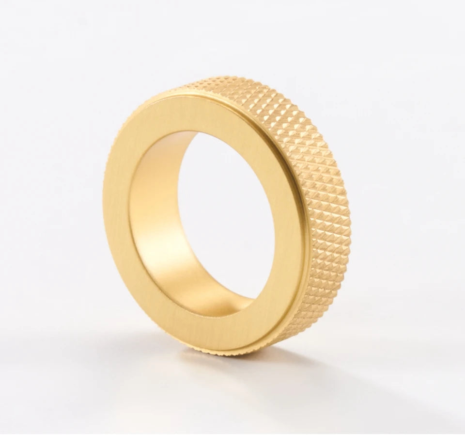 Gold ring cabinet knob with knurled surface on a white background.