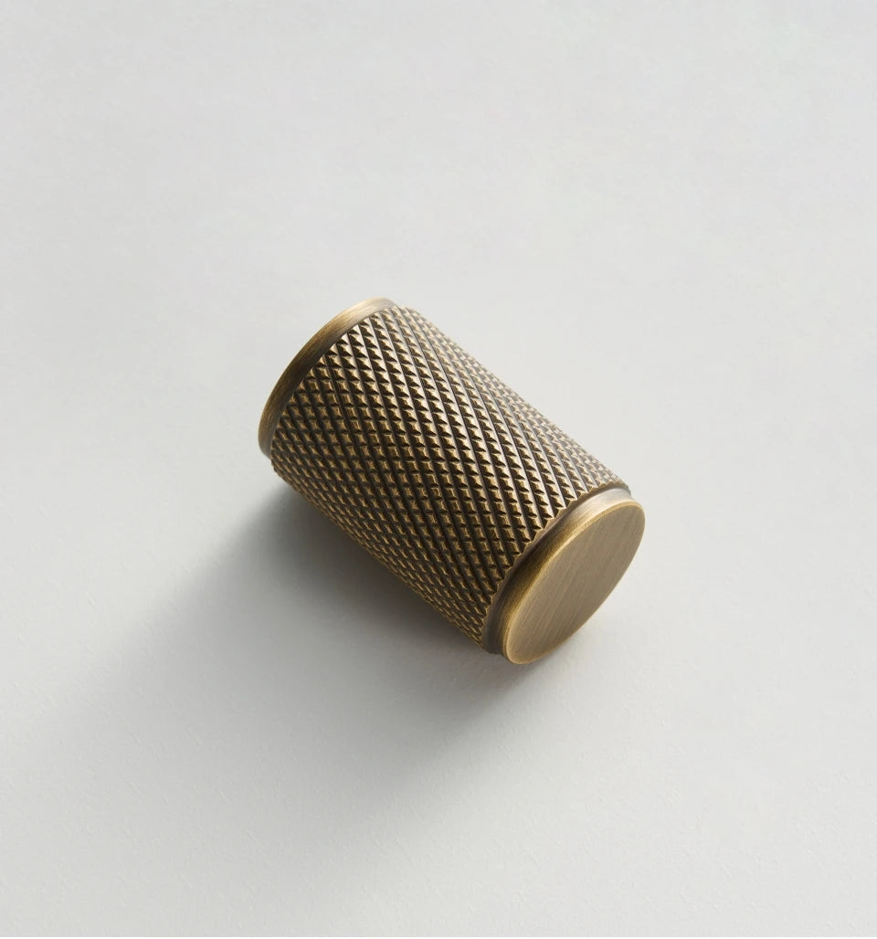 Knurled antique brass knob on white background.