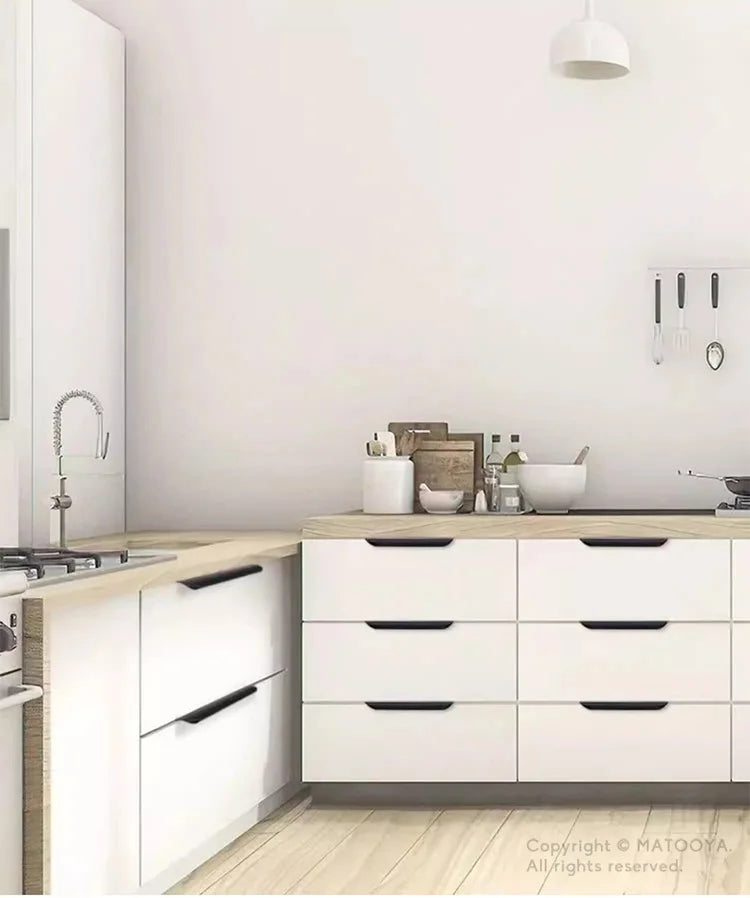 Modern kitchen with white cabinets with black edge pulls and wooden countertops.