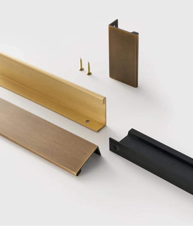 Hand pulling a strip of gold edge pull on a beige background.