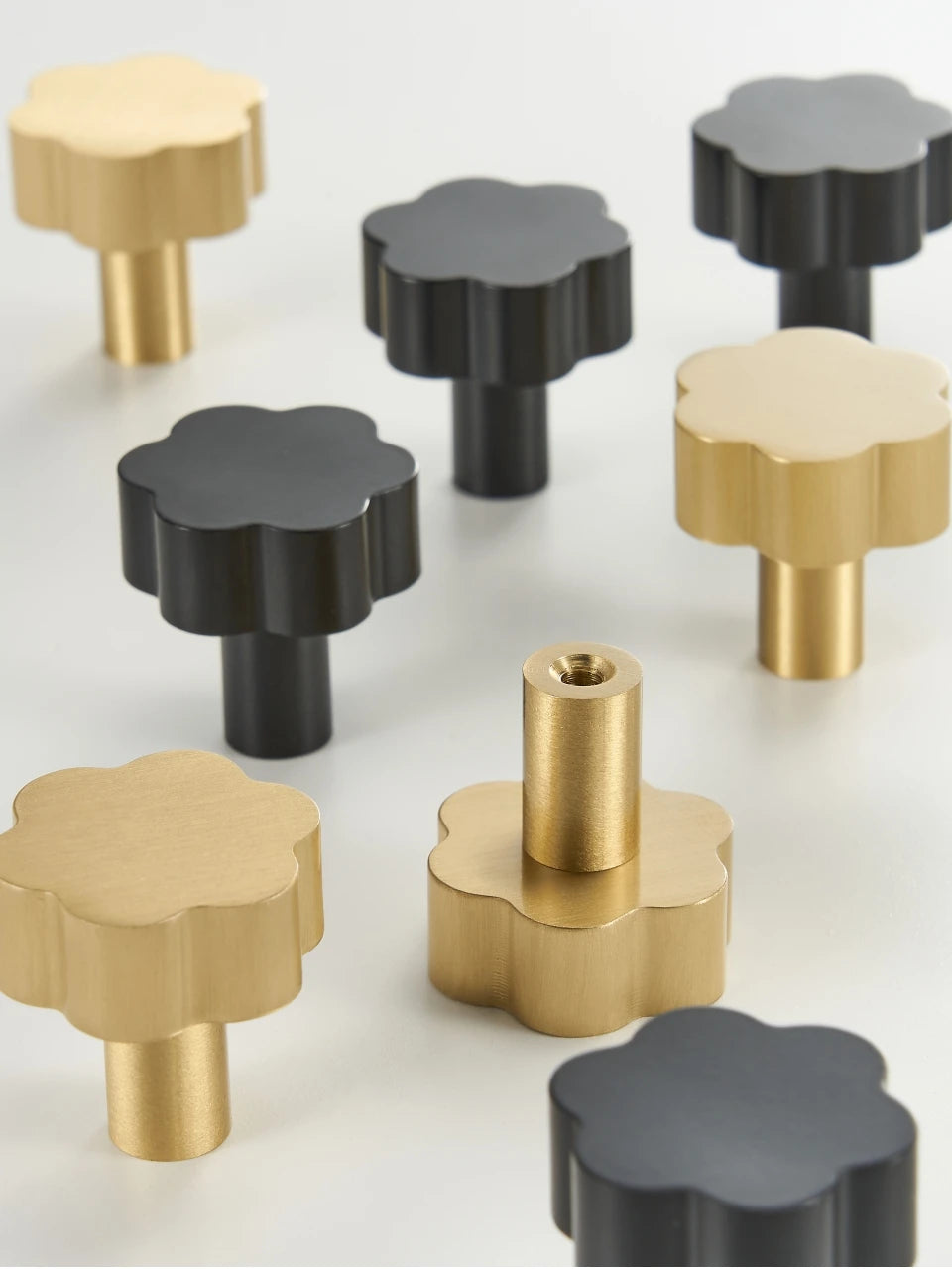 Set of gold and black brass flower cabinet knobs cabinet knobs on a white background.