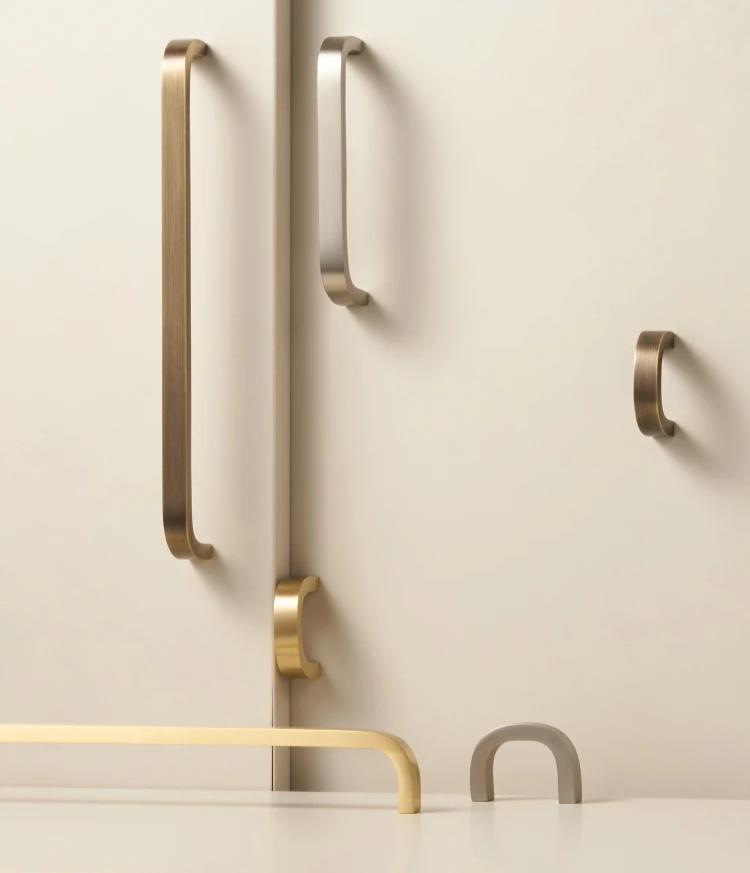 Set of gold and silver cabinet handles on a neutral background