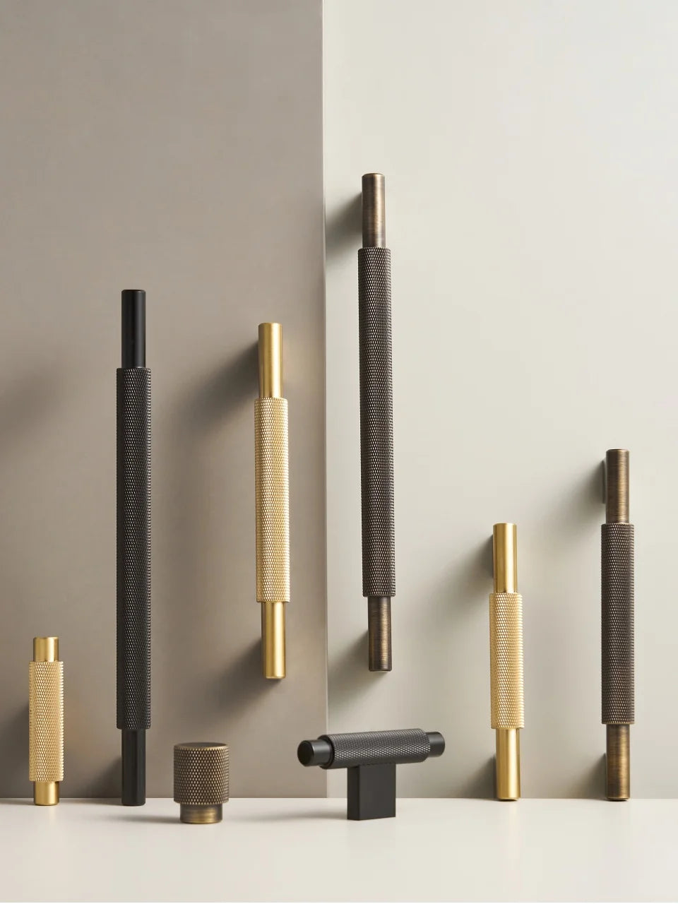 Set of various solid brass cross knurled handles in different designs and materials on a neutral background.