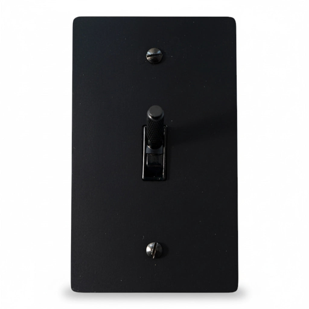 Black light switch cover with a single toggle on a white background