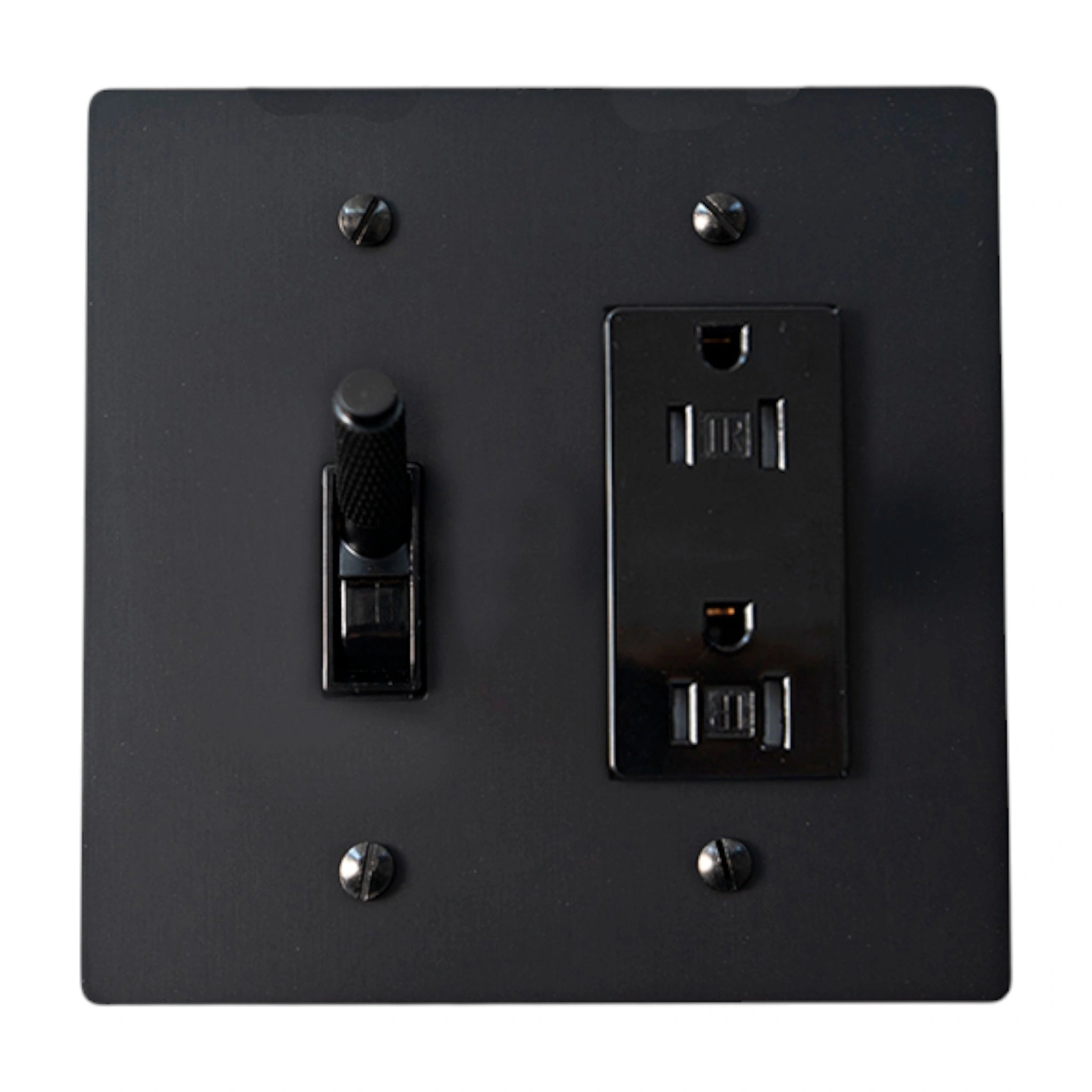 Black wall switch and socket combination on a white background