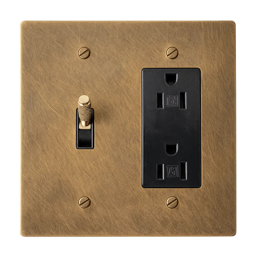 Brass wall plate with a switch and outlet on a white background