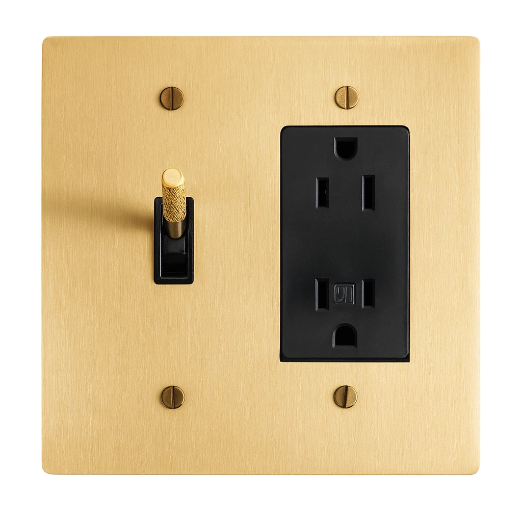 Gold wall plate with black toggle switch and outlet on a white background