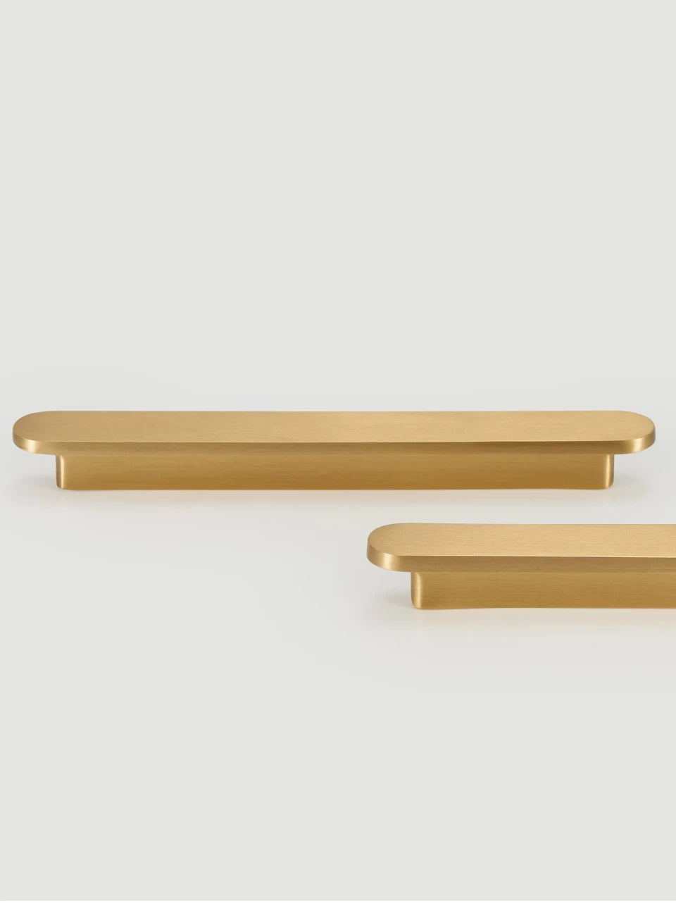 Two gold brass circular-end handles on a white background.