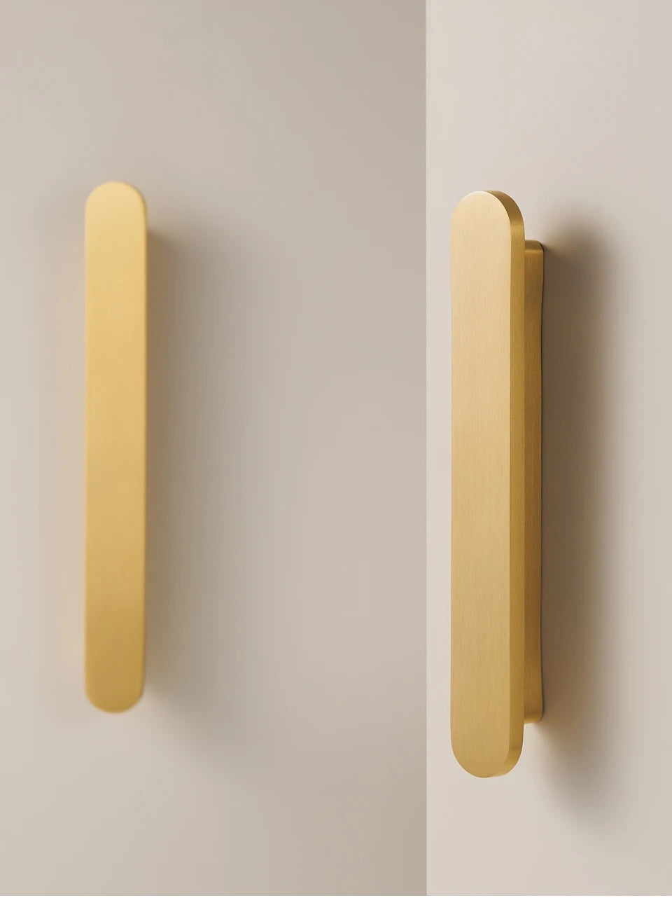 Set of gold brass circular-end handles on a beige and grey background.