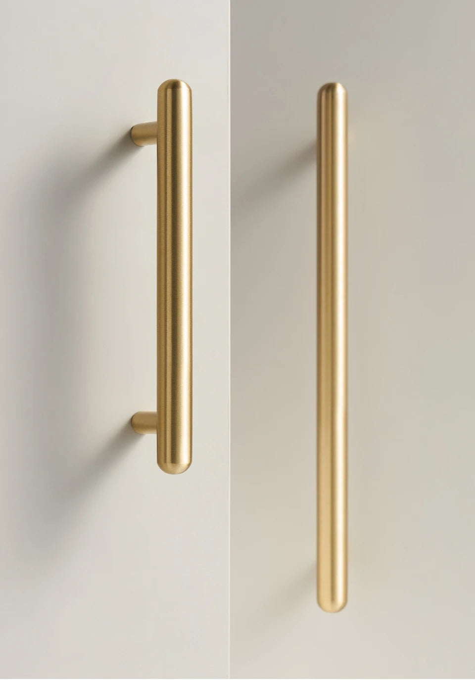 Two solid brass smooth gold cabinet round handles on a white background.