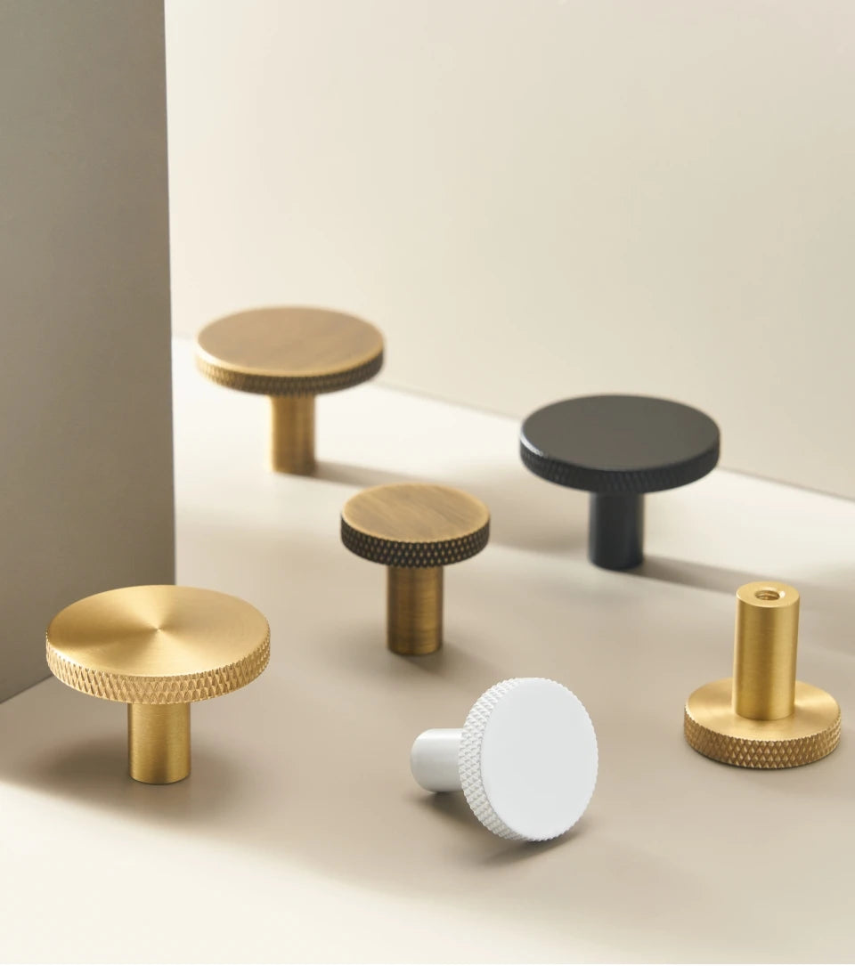 Set of various matte antique cabinet knobs on a neutral background.