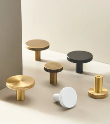 Set of various matte antique cabinet knobs on a neutral background.