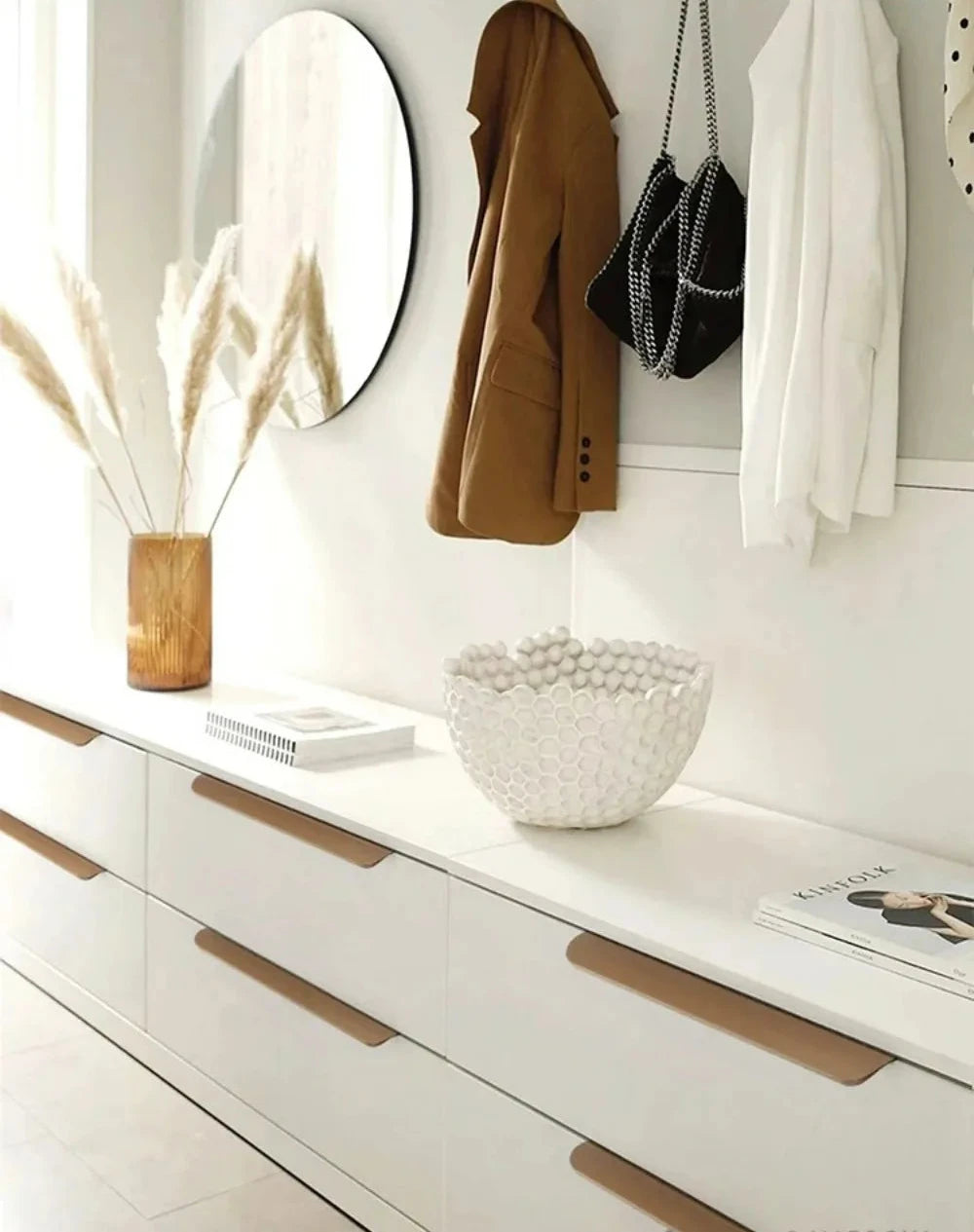 Close-up of a white dresser with grey edge pulls and an open drawer, showing a grey interior.