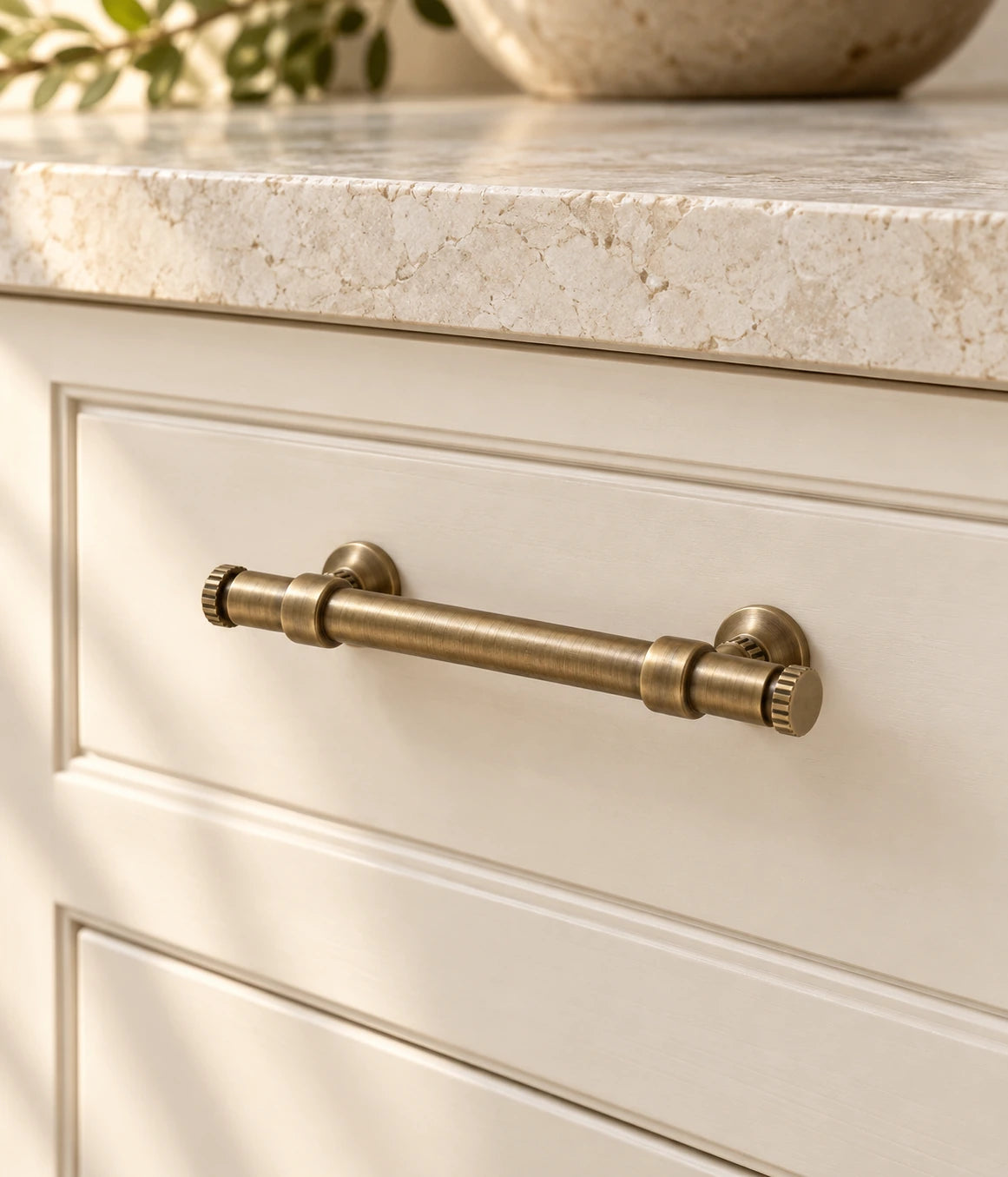 Antique brass ringed bar cabinet pull installed on a cream drawer