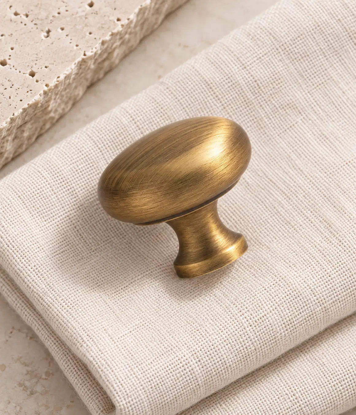Close view of the brushed brass mushroom knob’s rounded head and flared stem