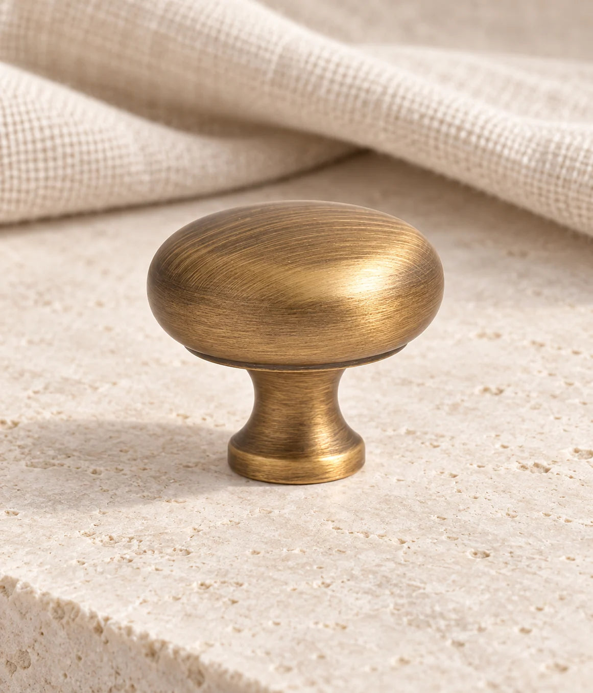 Antique brass 33 mm mushroom cabinet knob on ivory limestone