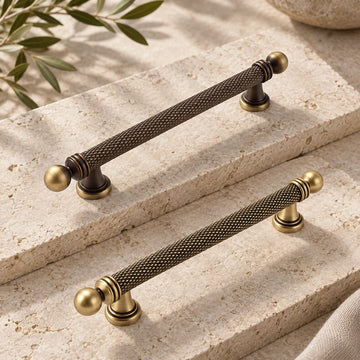 Dark and golden antique brass ball-end knurled cabinet pulls on limestone