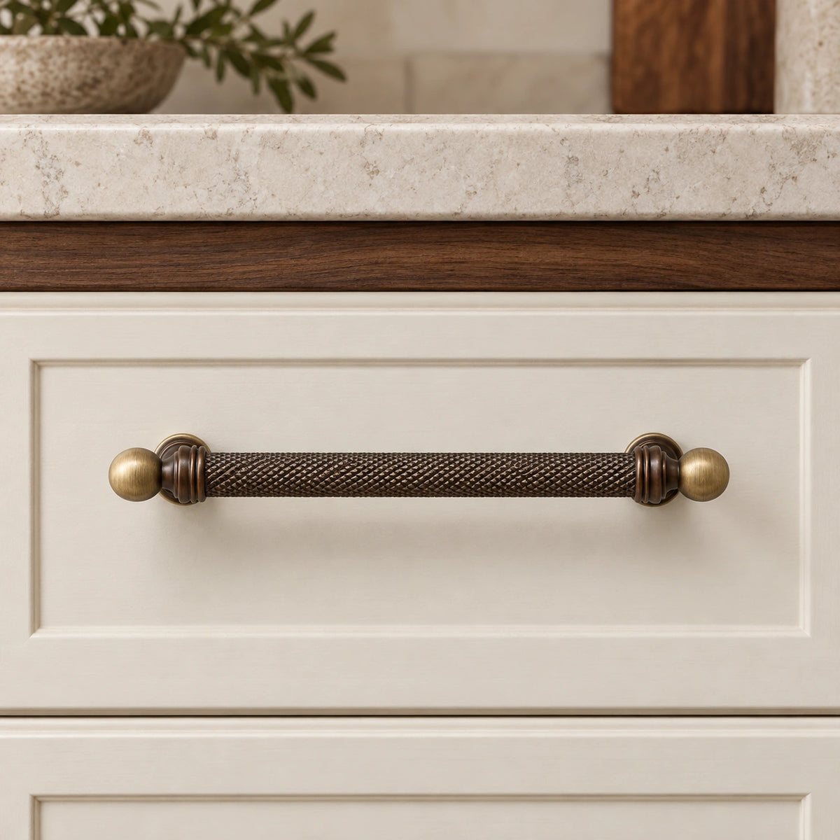 Dark antique brass ball-end knurled pull mounted on a cream drawer