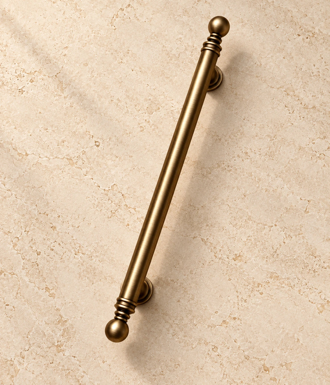 Antique Brass Ball-Finial Cabinet Pulls on warm ivory limestone